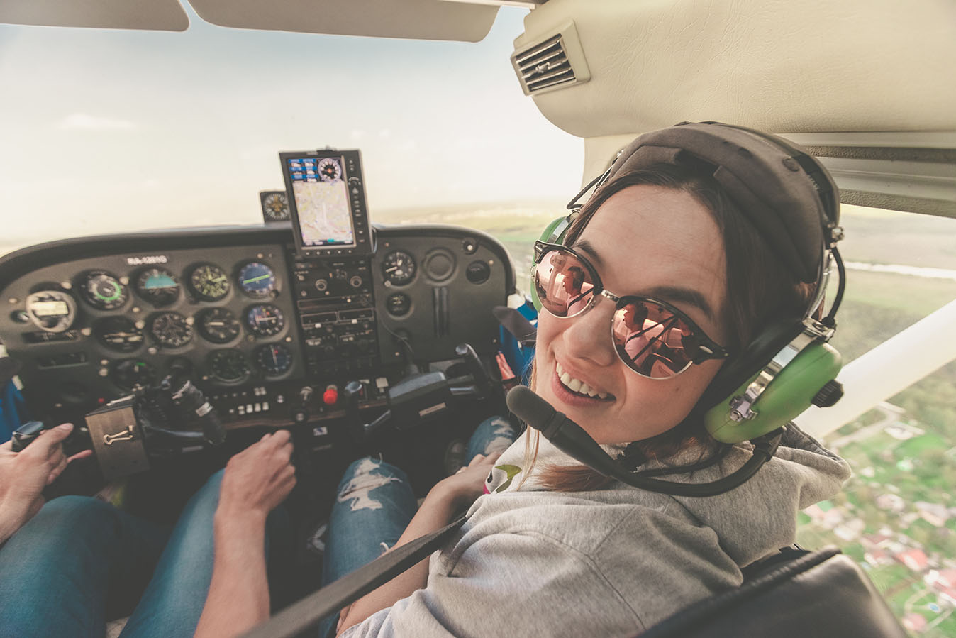 Confident female pilot with headset smiling in the private helic